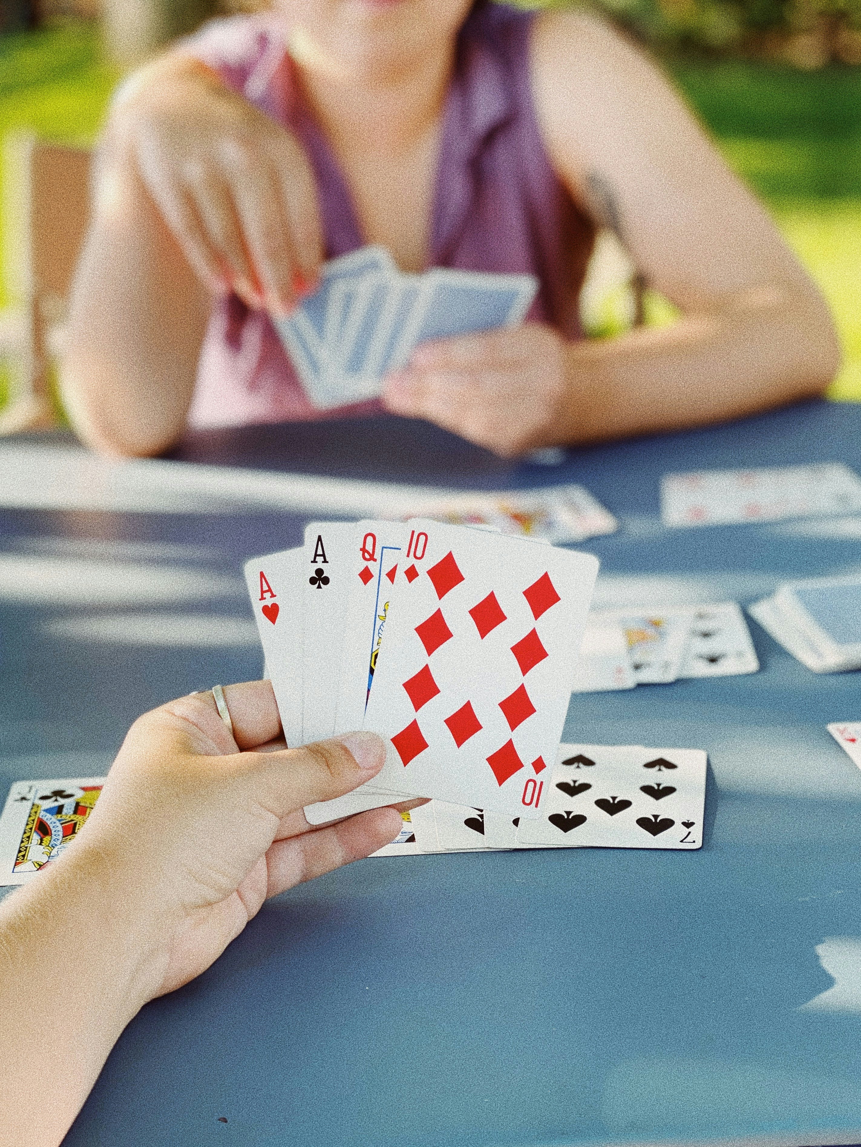 A woman holding playing cards during a gathering